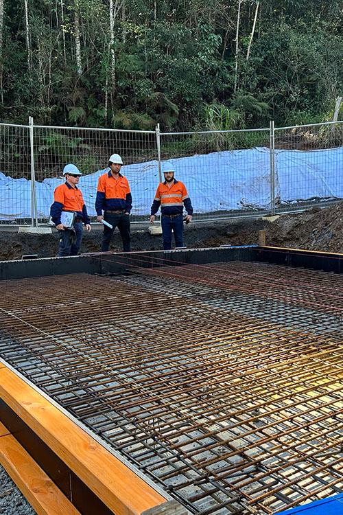 men looking at steel framing for slab